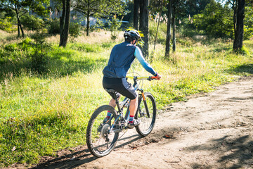 Man on his back riding a mountain bike in the forest