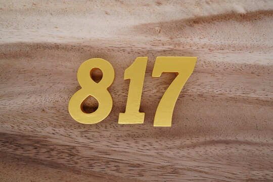 Golden Arabic numerals on a real brown and white wooden floor number 817