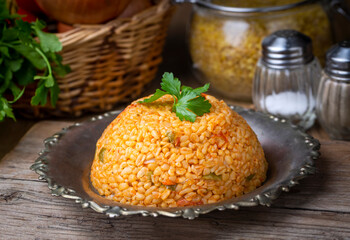 Traditional turkish bulgur pilaf with tomato sause in plate (Turkish name; meyhane pilavi)