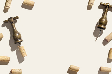 Wine corks and vintage corkscrew on beige background with shadows at sunlight. Minimal style layout with bottle cork, old bottle screw or opener, design concept for wine list, copy space