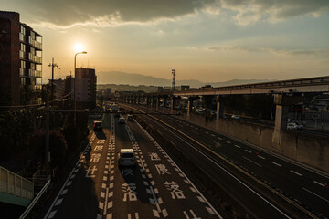 Naklejka premium 夕陽の差す街並みと「速度落とせ」の道路標示