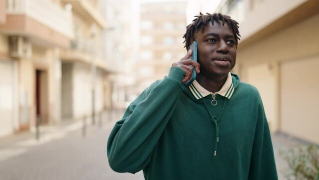 African american man smiling confident talking on the smartphone at street