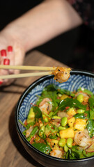 Poke bowls and other gourmet foods, with drinks and sushi on the table,