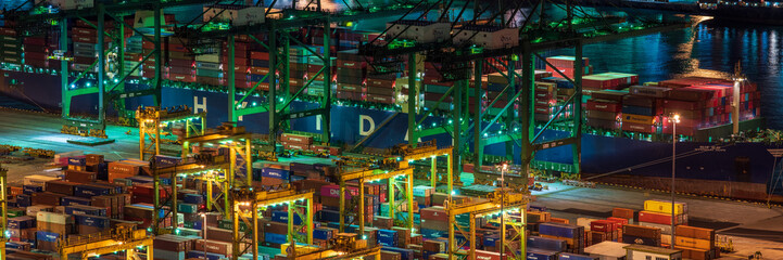 Fototapeta na wymiar Banner image of Singapore container yard full of containers and container ship at night.