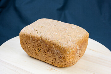 The freshly baked bread on a wooden board and black background close-up. Making bread. Top view.