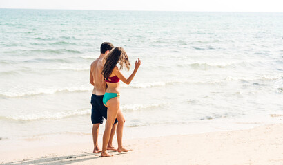 Vacation romantic love young happy smile couple in honeymoon travel holiday trip standing on sand at blue sky sea beach having fun and relaxing together on tropical beach.Summer travel
