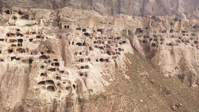 View of rock-hewn caves of ancient monastic complex of Vardzia in slopes of Erusheti Mountain near Georgian town of Aspindza in springtime