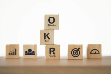 OKR black text (Objectives, Key and Results) on wooden cube blocks on table for  business target...