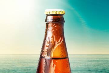 Close-up of the neck of wet glass bottle of dark beer against the background of the ocean and the...