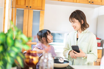 お母さんと一緒に料理をする小さな女の子