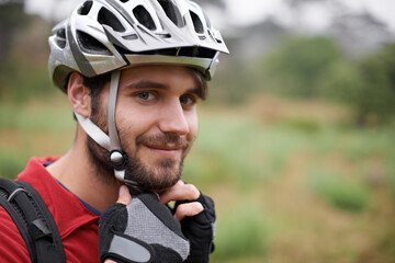 Its on tight. A young cyclist fastening his helmet.