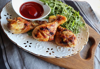 Dinner background. Grilled chicken legs with tomato sauce