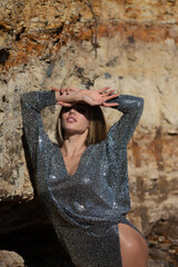 Beautiful young woman wearing fashionable spring clothes. Portrait of the fashion model in trendy dress. Fashion model outdoor. Shadow on face from hand.