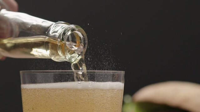 Slow motion apple cider poured into tumbler glass