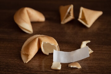 Broken fortune cookie on table with blank paper slip for your wish good luck