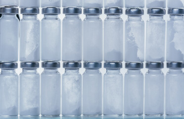 Glass medical ampoule vial for injection. Medicine is dry white drug penicillin powder or liquid with of aqueous solution in ampulla. Close up. Bottles ampule with aluminum cap on backgrounds gray.