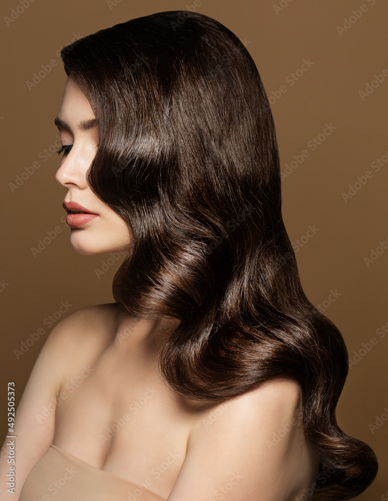 Wall mural model waves hairstyle. brunette beauty with smooth hollywood curls. woman with shiny wavy hair and n