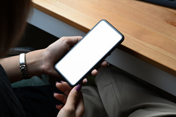 Woman hands holding mobile phone with white empty display for graphic display montage. Close up.