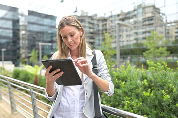 Businesswoman in town using digital tablet