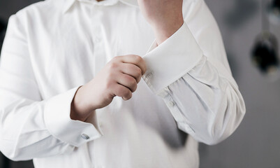 man buttoning cufflinks