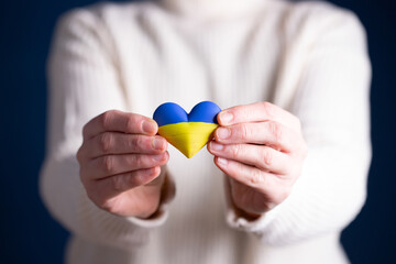 Heart flag of Ukraine in human hands. No war, peace for Ukraine concept.