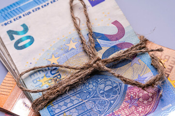 stack of euro banknotes tied with burlap string, close-up, wealth and prosperity concept