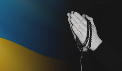 Close-up on ukrain flag with praying hands