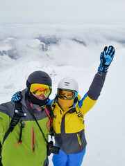 couple skier and snowboarder taking selfie at the mountain top
