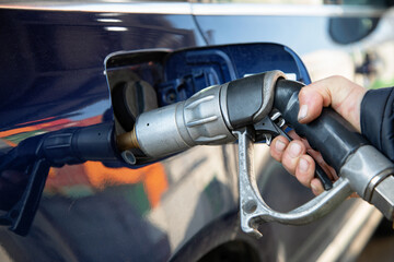 Fueling up the car at the gas station, road trip, driving, expensive, gas pump, gasoline, gas station, filling up, gas tank, getting gas, energy, power, industry, car trip, high gas prices, expensive 
