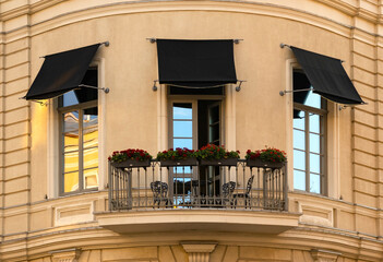 balcony with seating area on the facade of the house.