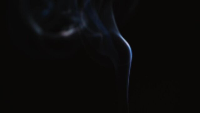 Abstract blue color smoke with a black background in slow motion. Realistic cloud smoke with streamline pattern.