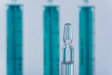 Medicine, Injection, vaccine and disposable syringe, drug concept. Sterile vial medical syringe needle. Macro close up. Glass medical ampoule vial for injection. Bottles ampule with aluminum cap.