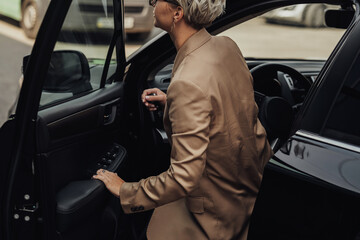 Woman Dressed in Rumpled Brown Jacket Getting of from the Car