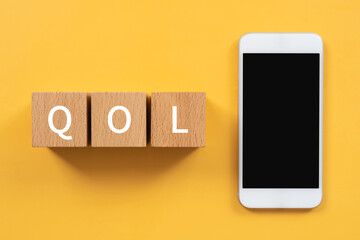 QOLのイメージ｜「QOL」と書かれた積み木とスマホ
