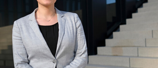 Female professional in a black shirt and grey suit jacket 