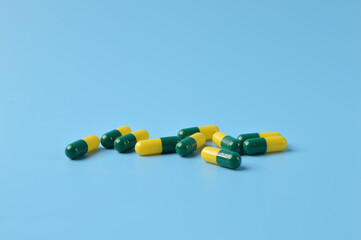 Bunch of pill capsules isolated on a blue background. Health concept.