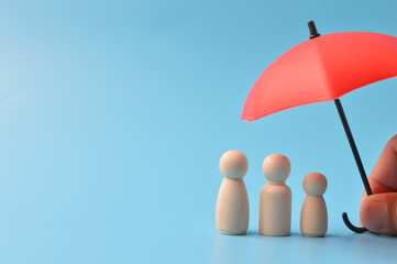 Red toy umbrella isolated on a blue background. Insurance coverage concept