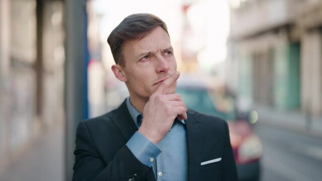 Young caucasian man with doubt expression standing at street