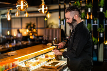 Sushi chef preparing Sushi at sushi restaurant.