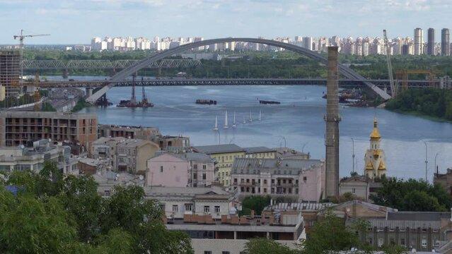 4K Aerial drone footage towards Havansky Bridge on Dinyeper River. Six white sail boats sailing towards drone where you can see the beautiful bridge behind the sail boats.