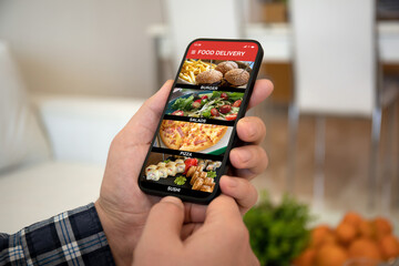 male hands holding phone with food delivery app on screen