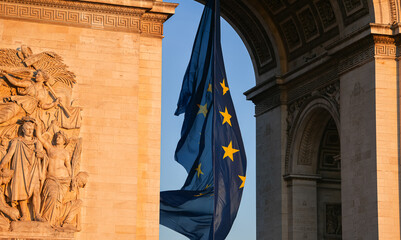 Flag of the European Union winding under the landmark Arch of Triumph building in Paris, France,...