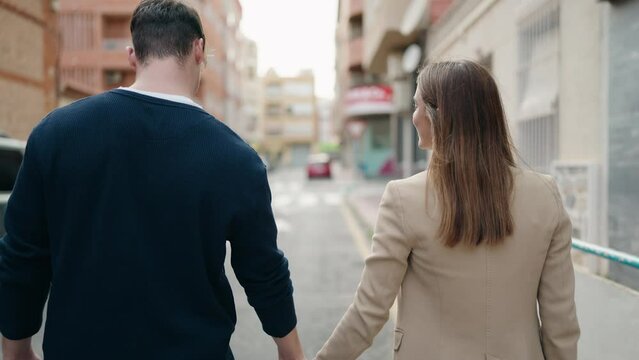 Young couple hugging each other and walking at street