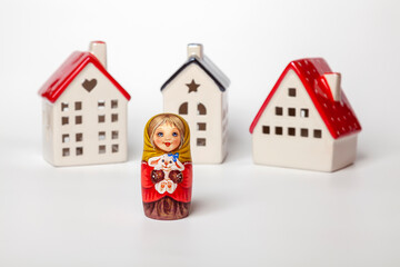Traditional Russian souvenir Matryoshka on the background of decorative houses