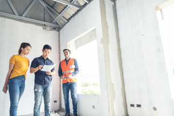 Fototapeta premium asian couple checking house with foreman engineering home inspection building house Walk home inspection with looking and pointing construction for check building home on job site to construction 2021