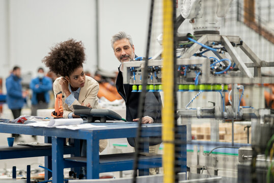 Engineers examining machinery in factory