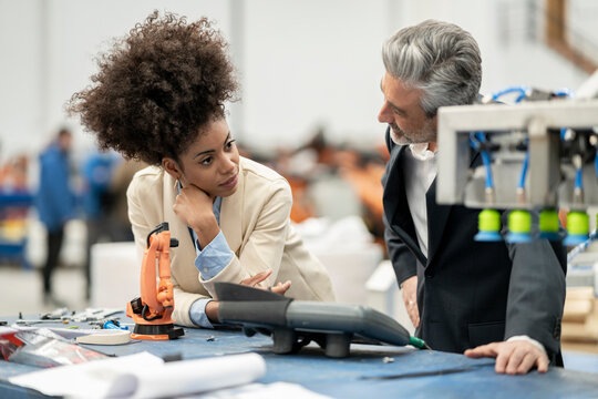 Engineers talking with each other standing in factory