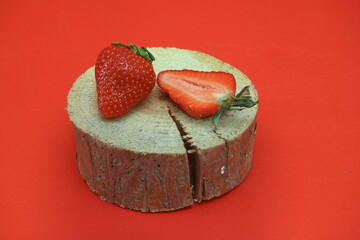 Red strawberries and half of the strawberries lie on the stump. on the background. close-up.