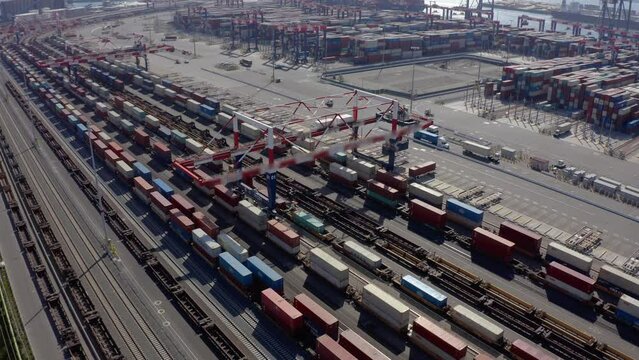 Flying above industrial railroad station with cargo trains and freight containers. Railroads and shipping container trains. Container train in the port. Cargo train moving in the container terminal. 