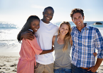 Double beach date. Cropped portrait of two happy couples enjoying a day at the beach.